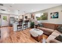 Open-concept living room flowing into kitchen, with hardwood floors and natural light from multiple windows at 6245 W 53Rd Ave, Arvada, CO 80002