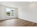 Well-lit room with hardwood floors, white walls, large windows offering natural light and neighborhood views at 8346 Cokedale Cir, Littleton, CO 80125