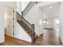 Bright entryway featuring hardwood floors, a staircase with dark wood railings, and white walls at 8346 Cokedale Cir, Littleton, CO 80125