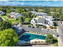 A higher aerial view showing the parking and pool, with landscaping and distant mountain range at 1820 Newland Ct # 213, Lakewood, CO 80214