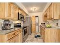 This modern kitchen has stainless steel appliances, light wood cabinets, stone backsplash, and a convenient laundry closet at 1820 Newland Ct # 213, Lakewood, CO 80214