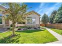 Landscaped front yard with lush green grass, mature trees, and inviting walkway at 14333 E Napa Pl # 5D, Aurora, CO 80014