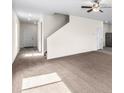 Bright living room featuring plush carpeting, ample space, and a ceiling fan at 7211 Dolores Ave, Frederick, CO 80530