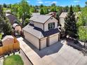Aerial view of a two-story house boasting a large driveway and an exterior storage unit at 2957 W Rowland Ave, Littleton, CO 80120