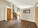 Entryway features wood flooring, a staircase, and a view into the home's open floor plan at 2957 W Rowland Ave, Littleton, CO 80120