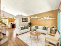 Bright living room with a neutral color scheme, white sofas, wood floors, and access to the kitchen at 2957 W Rowland Ave, Littleton, CO 80120