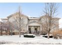 Front view of townhome, showcasing architectural details and winter setting at 6723 S Winnipeg Cir # 104, Aurora, CO 80016