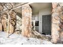 Inviting entryway with stone columns and a gray front door at 6723 S Winnipeg Cir # 104, Aurora, CO 80016