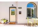 The front porch has a cute yellow door, a black mailbox, and seating at 3110 N Franklin St, Denver, CO 80205