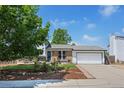Charming home with brick accents, landscaped front yard, and a two-car garage with a paved driveway at 1153 S Biscay St, Aurora, CO 80017