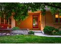 Inviting front entrance with a red door, cozy seating and landscaped garden at 250 S Dahlia St, Denver, CO 80246