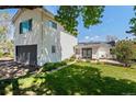 Beautiful backyard featuring a lush green lawn, garden area, patio, and white siding on the home at 6303 W Exposition Ave, Lakewood, CO 80226