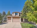 Charming two-story home features a three-car garage, well-manicured lawn, and mature shade tree at 13891 Muirfield Ct, Broomfield, CO 80023