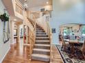 Grand foyer with a curved staircase, hardwood floors, and open access to living spaces at 13891 Muirfield Ct, Broomfield, CO 80023