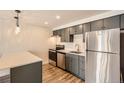 Contemporary kitchen boasts stainless appliances, gray cabinets and a breakfast bar at 1302 S Parker Rd # 229, Denver, CO 80231