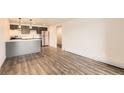 Open-concept living room featuring modern gray cabinets, stainless steel appliances, and wood-look floors at 1302 S Parker Rd # 229, Denver, CO 80231