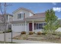 Charming two-story home featuring a white garage door, gray siding, and landscaped front yard at 18997 E 51St Pl, Denver, CO 80249