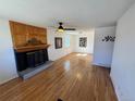 Bright living room features hardwood floors, a ceiling fan, and a fireplace with wood and black trim at 6213 Gray St, Arvada, CO 80003