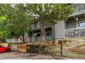 Exterior view of condos showing wooden retaining wall and mature landscaping at 910 S Walden St # 106, Aurora, CO 80017