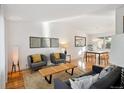 Open-concept living and dining area with hardwood floors, modern furnishings, and plenty of natural light at 7410 S Dahlia Ct, Centennial, CO 80122