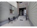 Charming home entrance with stone accents, outdoor seating, and a welcoming front door at 9750 Taylor River Cir, Littleton, CO 80125
