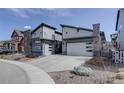 Contemporary home featuring a two-car garage, stylish siding, stone accents, and manicured landscaping at 9750 Taylor River Cir, Littleton, CO 80125