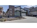 Modern home exterior with stone accents, stylish siding, two-car garage, and landscaped front yard at 9750 Taylor River Cir, Littleton, CO 80125