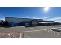 Commercial building exterior with a blue roof and timber details, set in a large parking lot at 725 Cottonwood Ave, Bennett, CO 80102