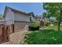 Side yard view shows manicured landscaping, a privacy fence, and the home's exterior at 18384 E Bethany Pl, Aurora, CO 80013