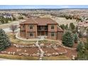 Elegant two-story home boasts stone accents, lush landscaping, and large bay windows at 5261 Sedona Dr, Parker, CO 80134