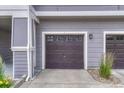 Attached garage with paneled garage door and white trim for a modern look at 17225 Lark Water Ln # C, Parker, CO 80134