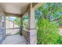 Inviting covered front porch with stone columns offers a cozy outdoor space at 1920 E 145Th Ave, Thornton, CO 80602