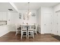 Cozy dining room with white chairs, wood floors, and decorative wall art for a modern look at 5744 Alton St, Denver, CO 80238