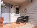 Inviting front porch with seating area, decorative rug, and stylish accents, creating a warm welcome at 7292 Tenby Way, Castle Pines, CO 80108