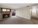 Living room with a stone fireplace and a sliding glass door leading to the balcony at 4691 S Decatur St # 212, Englewood, CO 80110