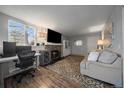 Living room with stone fireplace, hardwood floors, and a view of the kitchen at 17403 E Mansfield Ave # 91Er, Aurora, CO 80013