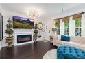 Cozy living room featuring a fireplace, modern lighting, and a large window providing natural light at 9620 W Chatfield Ave # D, Littleton, CO 80128