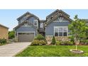 Charming exterior view showcasing the home's architectural details, lush landscaping, and attached two-car garage at 2896 Gemini Loop, Broomfield, CO 80023