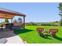 Expansive backyard with lush lawn, mature trees, outdoor seating, and covered area perfect for entertaining at 1294 Kittery St, Castle Rock, CO 80104