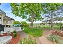 Beautiful backyard featuring a manicured lawn, mature trees, and a view of the golf course at 8040 W 78Th Cir, Arvada, CO 80005