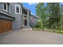 Inviting front entrance with wood door, an American flag, and an attached three-car garage at 6637 Berry Bush Ln, Evergreen, CO 80439