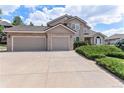 A beautiful home featuring a spacious three-car garage and meticulously kept landscaping at 20886 Parliament Pl, Parker, CO 80138