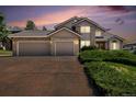 Exterior shot of home at dusk highlighting garage and landscaping at 20886 Parliament Pl, Parker, CO 80138