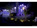 A well-lit home exterior showcasing a landscaped yard at night, highlighting curb appeal with garden bed lighting at 1102 Conifer Ct, Highlands Ranch, CO 80126