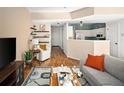 Cozy open-concept living room with hardwood floors, stylish decor, and an adjacent kitchen area at 9150 Gale Blvd # 1, Thornton, CO 80260