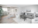 Bright living room featuring hardwood floors, modern decor, and an adjacent kitchen and dining area at 5539 Atchison St, Denver, CO 80239