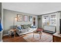 Cozy living room with gray sofa, wood floors, and a round coffee table, filled with natural light at 2101 S Josephine St # 202, Denver, CO 80210
