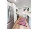 Bright kitchen featuring stainless steel appliances, white cabinetry, and modern countertops at 3355 Moorhead Ave, Boulder, CO 80305