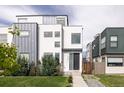 Modern two-story home with a combination of stucco and metal siding, professionally landscaped yard, and inviting entrance at 2685 S Acoma St, Denver, CO 80223