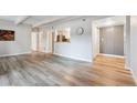 Open-concept living room with hardwood flooring, white trim, and access to kitchen at 9700 E Iliff Ave # A3, Denver, CO 80231